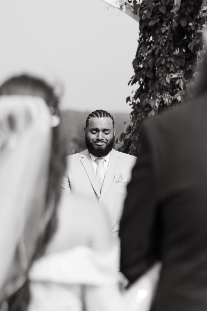 groom crying while bride walks down the aisle