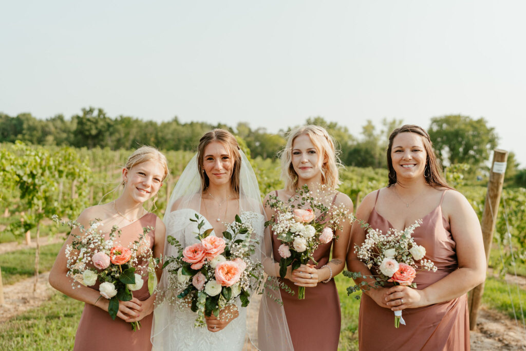 bridesmaids in rose gold dresses with bride