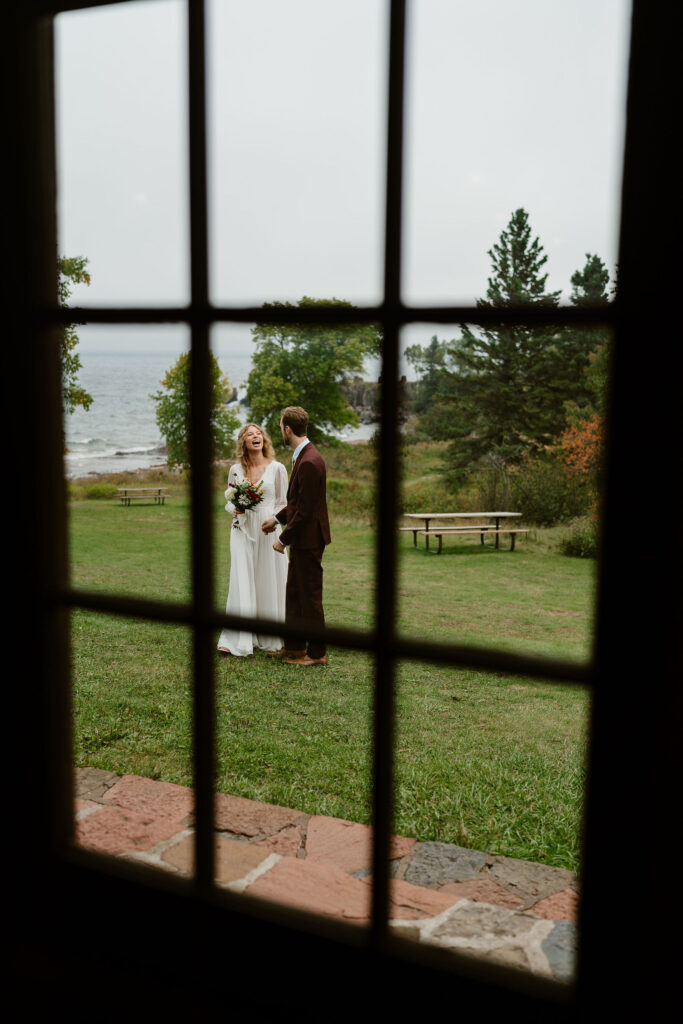 A cozy picnic shelter adorned with autumnal foliage serves as the backdrop for Annie and Josiah's north shore elopement ceremony in minnesota surrounded by close friends and family.