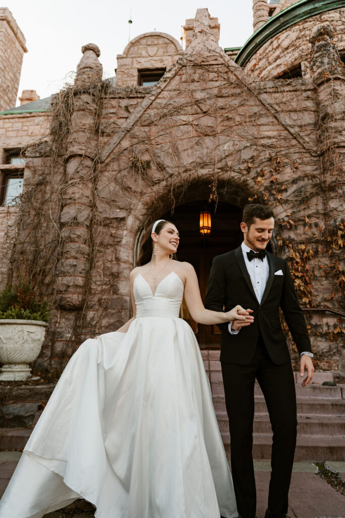bride and groom stand out in front of the fairytale-esque Van Dusen Mansion