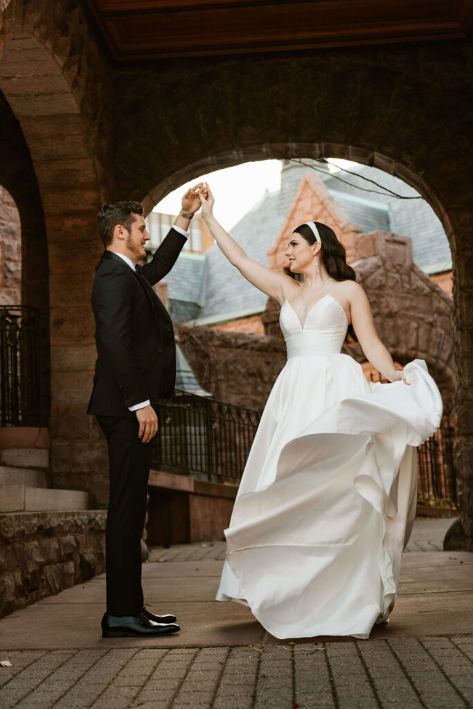 bride and groom dancing out in front of the fairytale-esque Van Dusen Mansion