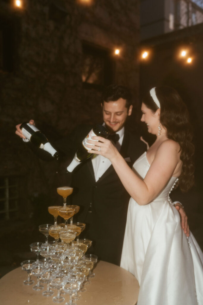 bride and groom pour over a champagne tower