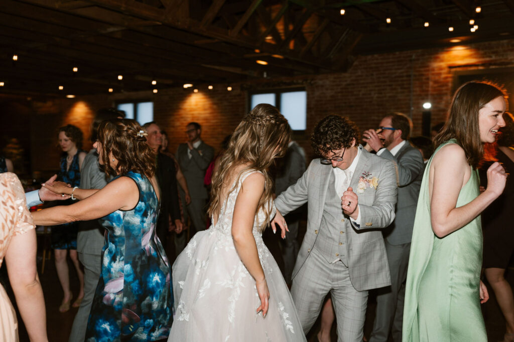 Wedding party dances in an industrial Colorado wedding venue