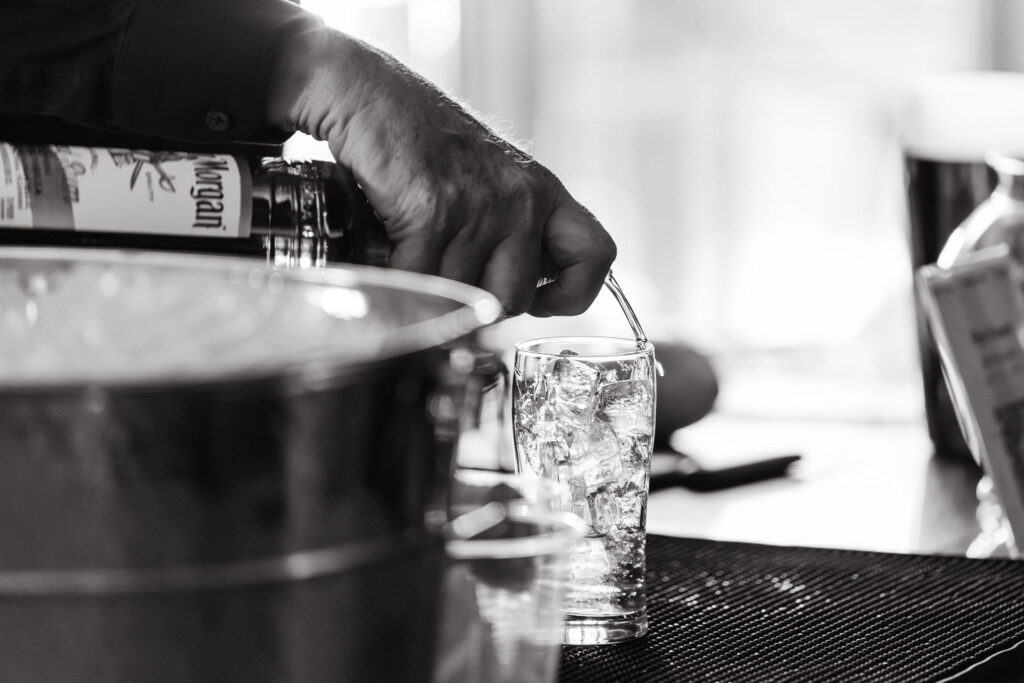 Wedding bartender pours captain morgan into a shot glass