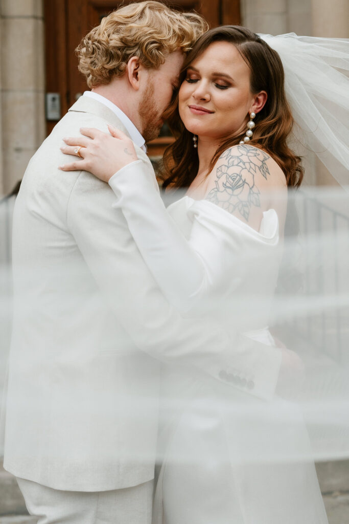 Bride and groom stand in front of St. Paul College Clubs vintage mansion