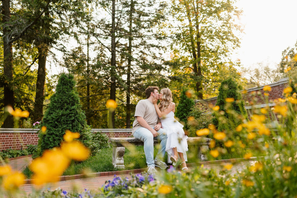 A couple sits in the gardens at Glensheen Mansion for some classy engagement photos