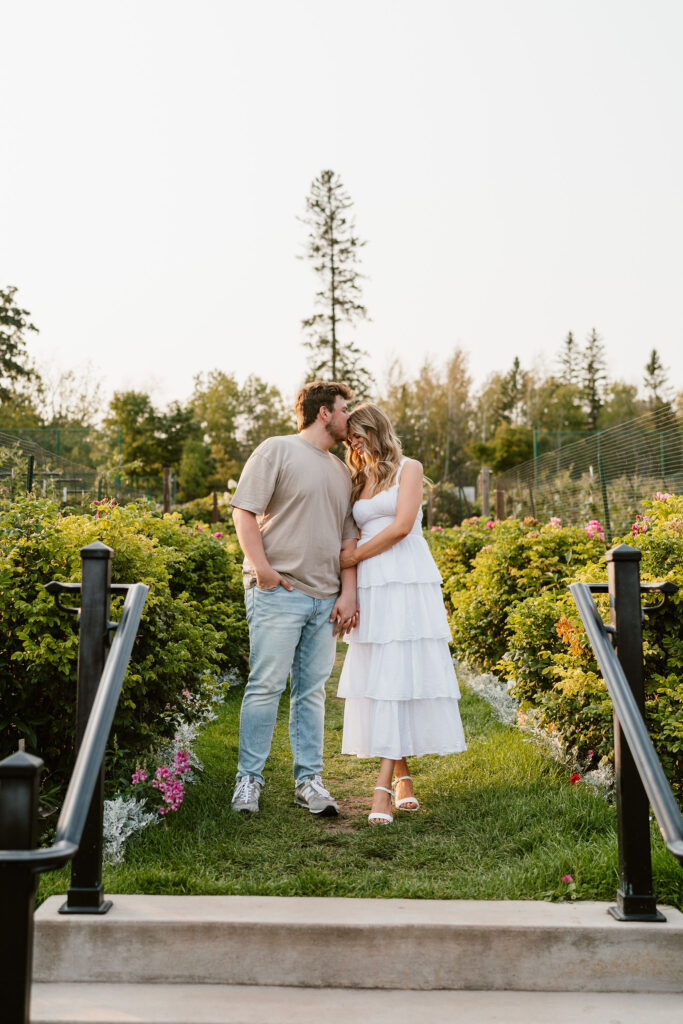 A couple stands in the gardens at Glensheen Mansion for some classy engagement photos