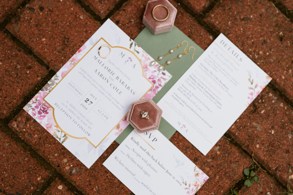 Classic wedding stationery flat lay with green and pink wedding colors