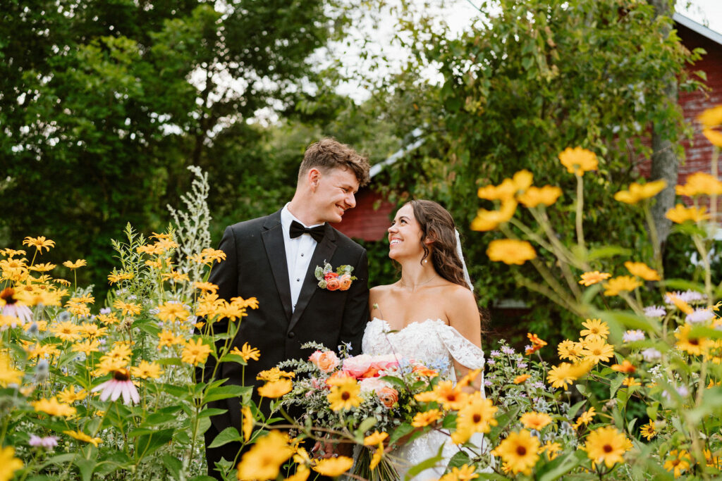 Bride and groom have some portraits in a pristinely kept garden in a Wisconsin backyard with wildflowers