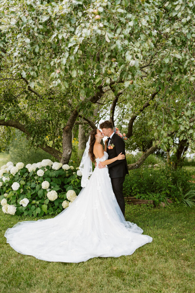 Bride and groom have some portraits in a pristinely kept garden in a Wisconsin backyard