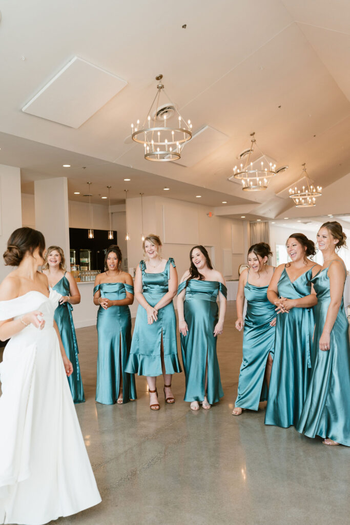 Bride and bridesmaids first look with bridesmaids in jewel toned dresses