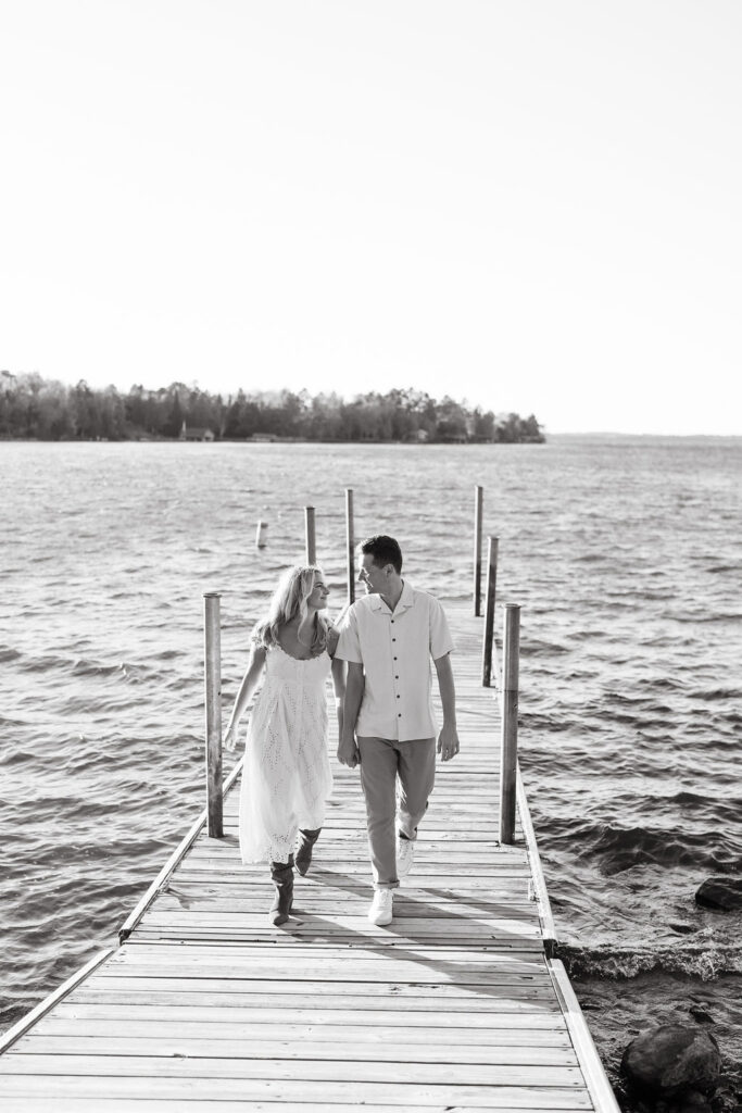 Couple walks across the dock at Lake Vermilion for their fall engagement photos