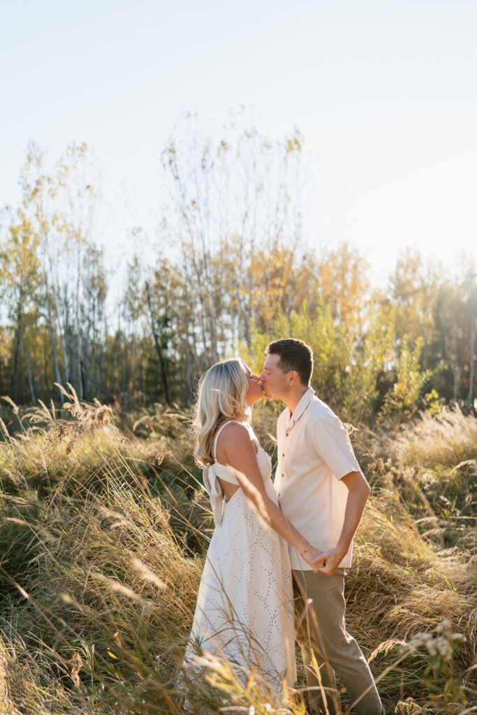 Couple takes engagement photos in the fall foliage at their family's Minnesota cabin on the lake