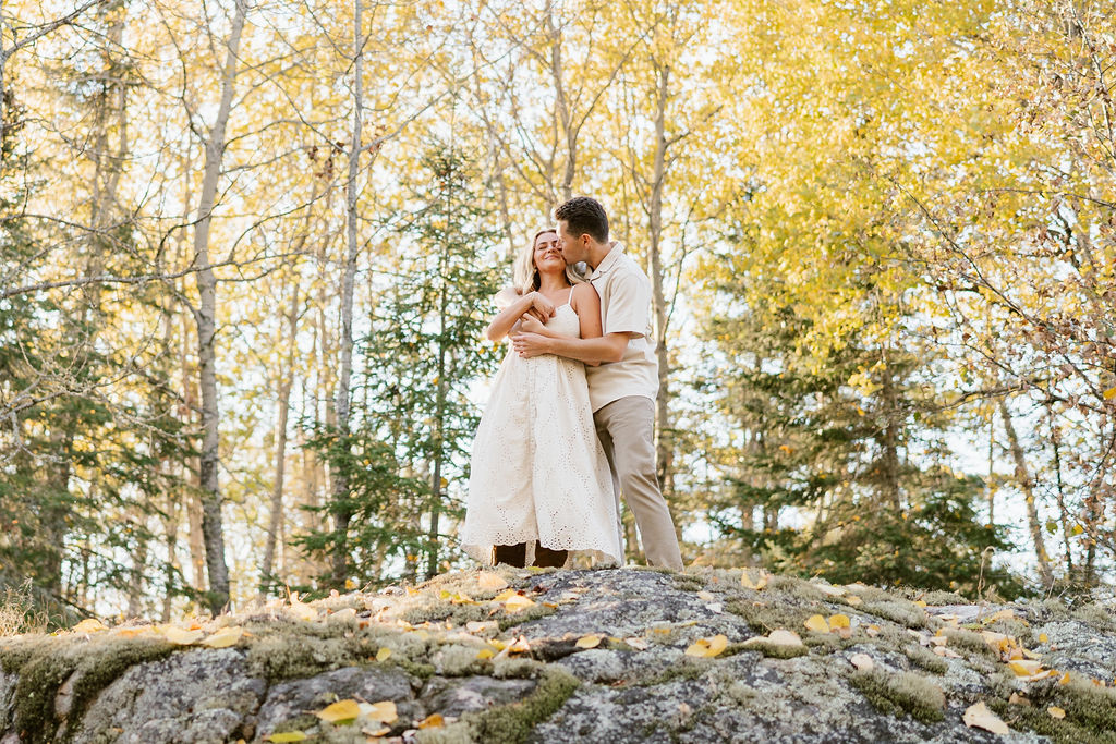 Couple takes engagement photos in the fall foliage at their family's Minnesota cabin on the lake