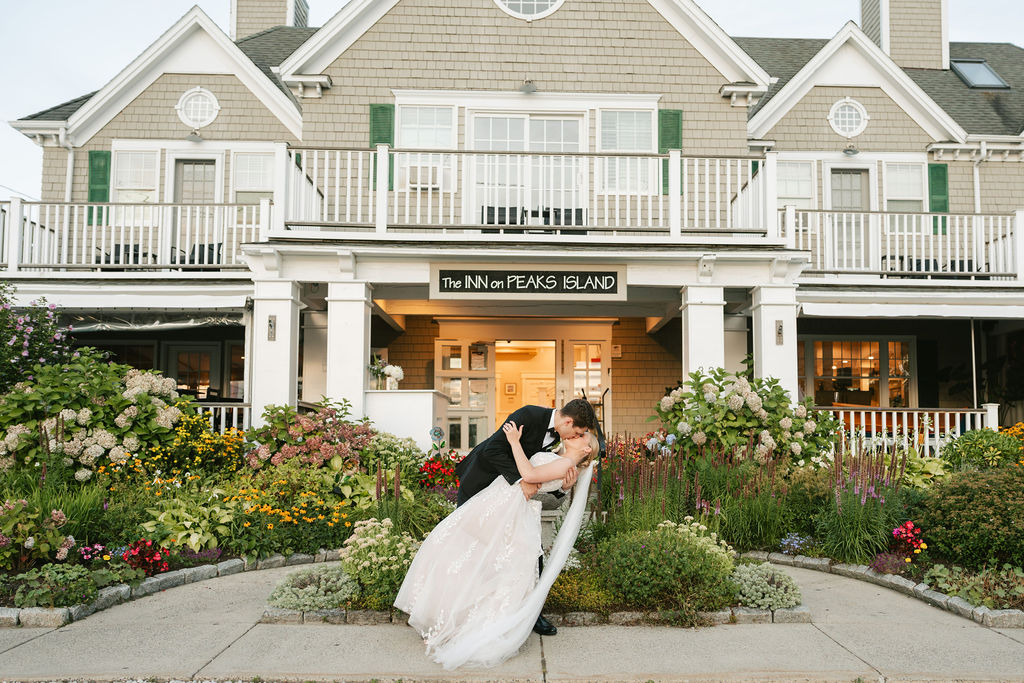 Bride and groom kiss in front of The Inn on Peaks Island