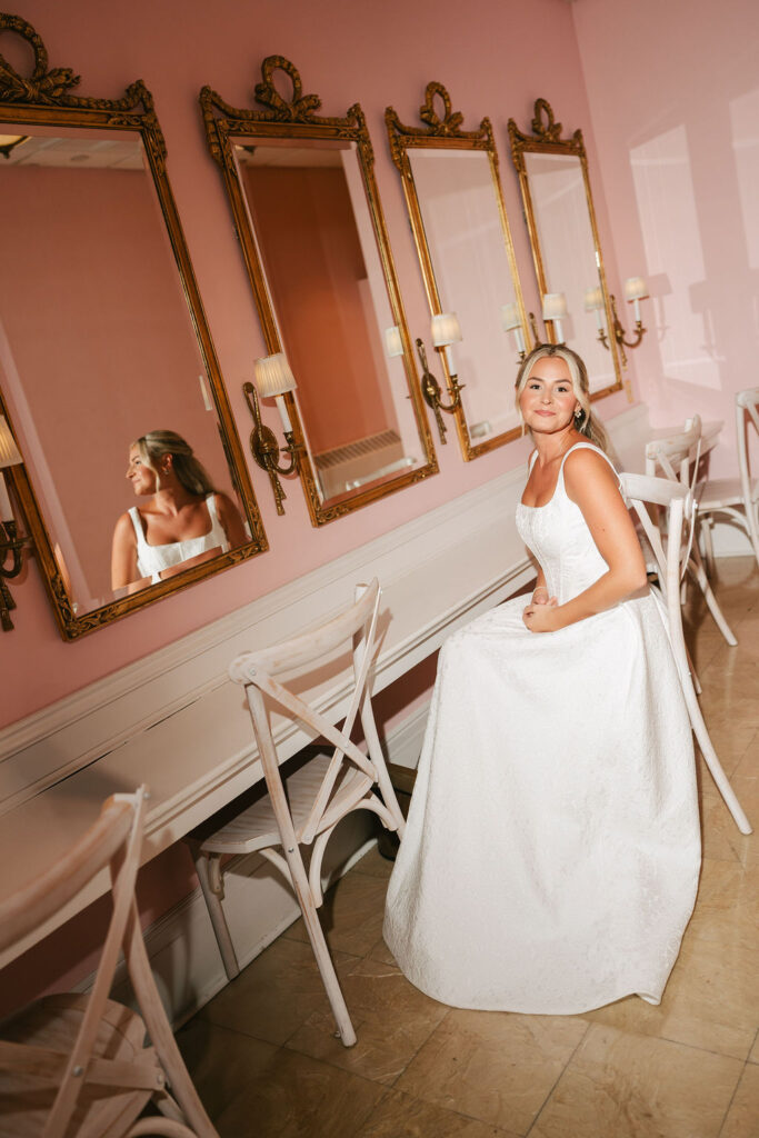 Bride sits in her gown in the pink bridal suite in Minneapolis Club