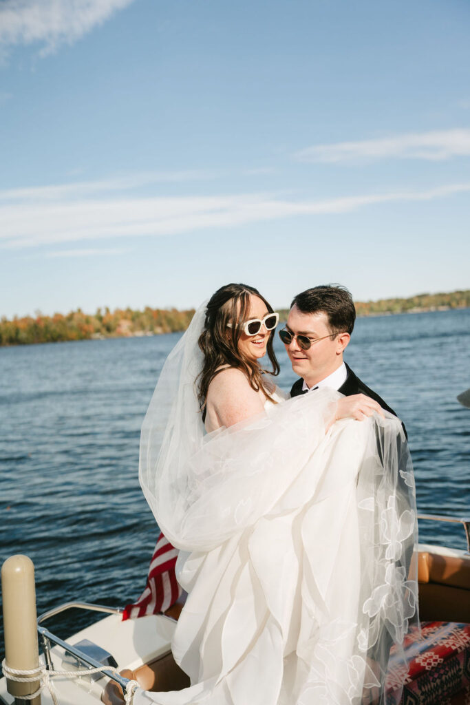 Bride and groom ride on a vintage boat on Gull Lake