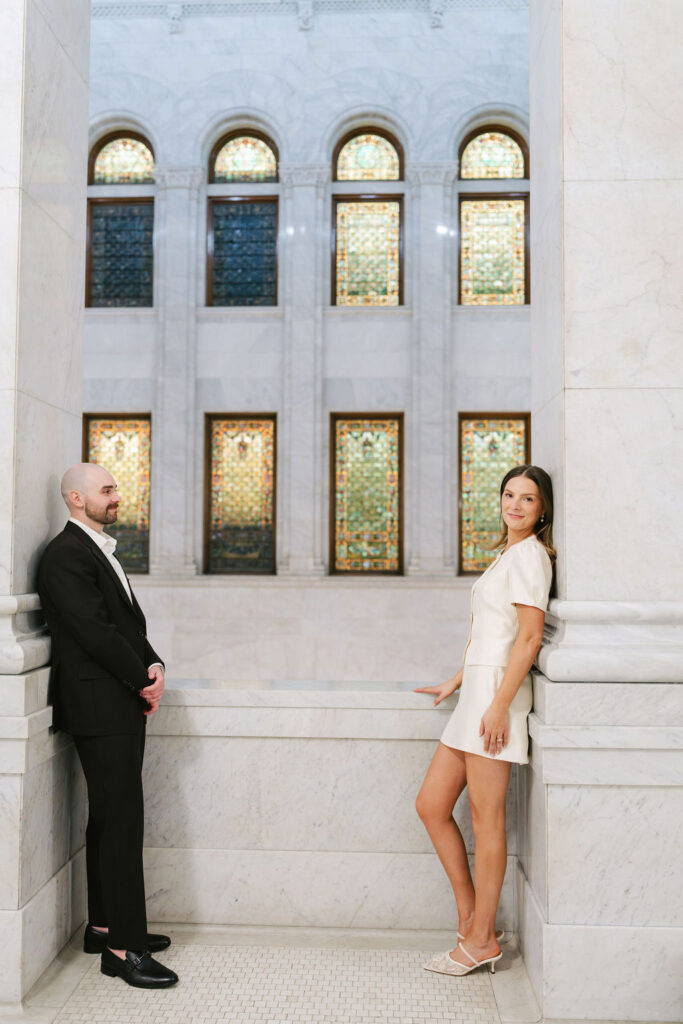 Bride and groom stand by a stained glass window in Minneapolis City Hall