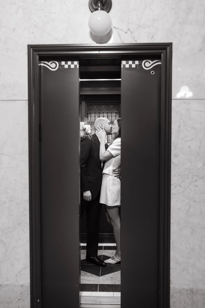 Bride and groom kiss in a Minneapolis City Hall elevator