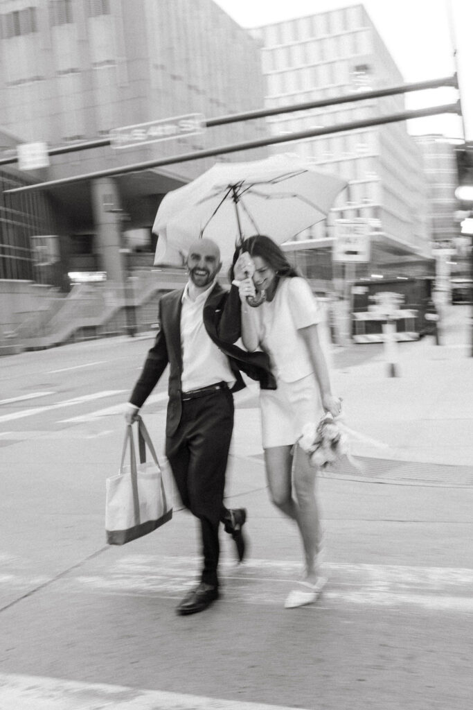 Bride and groom run across a sidewalk in Minneapolis