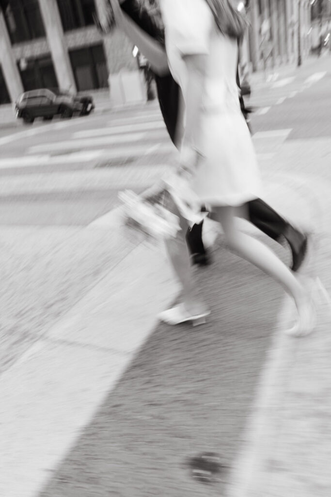 Bride and groom run across a sidewalk in Minneapolis