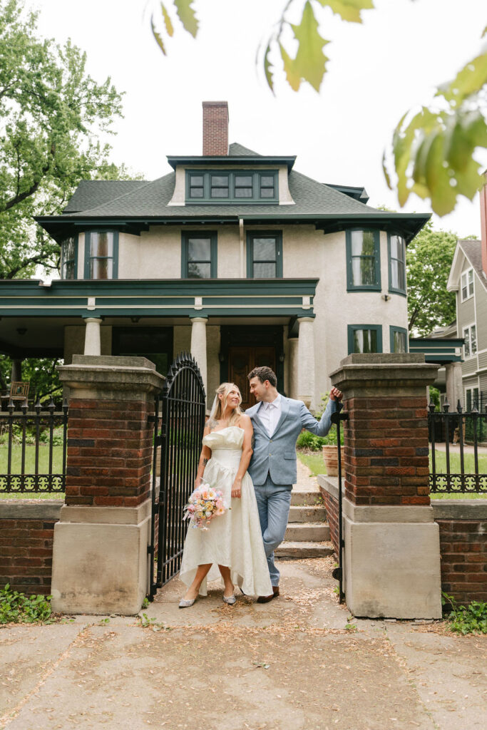 Bride and groom stand at the entrance of a private estate in St. Paul