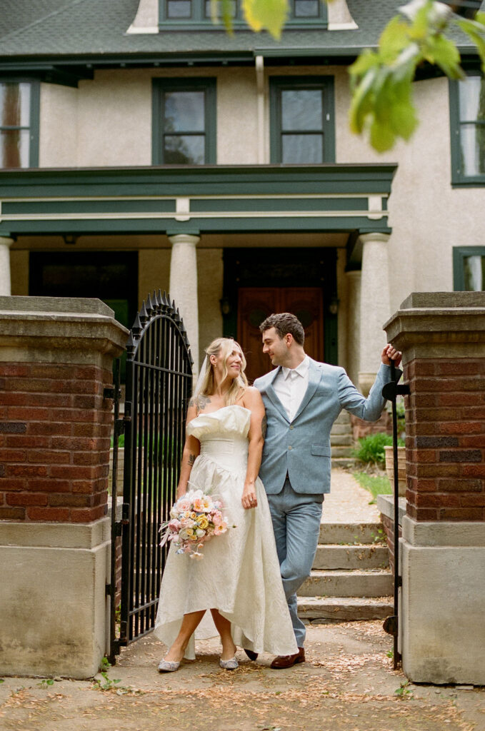 Bride and groom stand at the entrance of a private estate in St. Paul